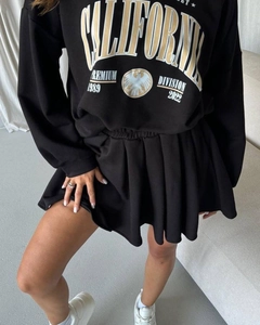 Detail of black sweatshirt with California print and pleated skirt two-piece outfit