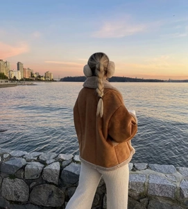 Détail d'une veste en daim marron avec col en peau de mouton au coucher du soleil à la mer