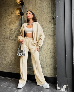 Detail of beige zip-up jacket and high-waisted wide-leg pants set with center crease design