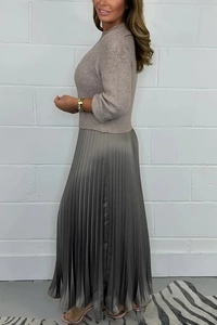 Detail view of beige knit long sleeve top paired with grey pleated skirt texture