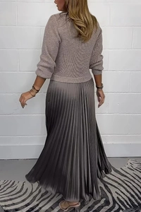 Detailed knit texture of oatmeal sweater and pleated grey midi skirt on a female model