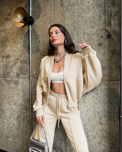 Detail of beige zip-up hoodie and jogger set with soft fleece fabric and stylish texture