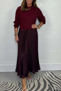 Detail of burgundy knit top with vertical texture and pleated satin skirt combination