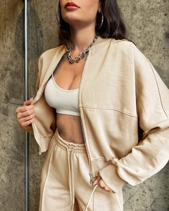 Detail of beige zip-up sweatshirt and matching drawstring joggers in premium cotton fabric