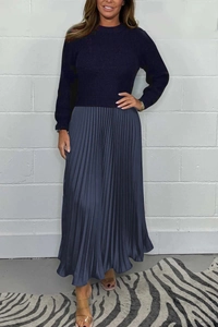 Close-up of the fine knit texture and elegant pleated satin fabric of the navy dress