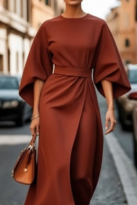 Detail of elegant terracotta maxi dress featuring lantern sleeves and a cinched belted waist