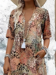 Détail de robe d'été avec col en V, imprimé fleuri bohème et manches en dentelle ajourée
