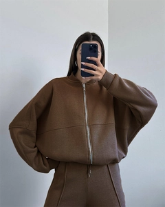 Detail of dark brown zip-up hoodie set with straight-leg pants and metal zipper