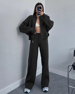 Detail of dark grey zip-up hoodie and high-waist wide-leg trousers with front seam