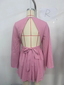 Vue détaillée du dos d'une robe rose dos nu avec un nœud élégant attaché à la taille