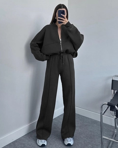 Detail view of dark charcoal grey zip-up sweatshirt and wide-leg trousers set