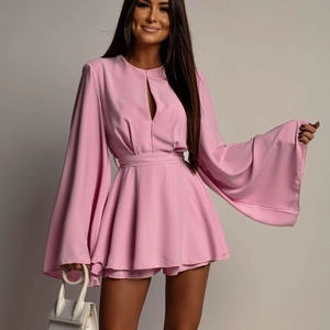 Détail des manches évasées roses et de la taille ajustée sur cette robe de soirée