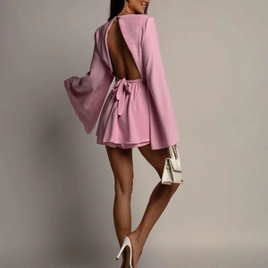 Détail d'une mini robe rose dos nu avec un nœud délicat et des manches larges évasées