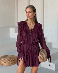 Detail eines eleganten burgunderroten Chiffonkleids mit Volants und V-Ausschnitt-Schleife