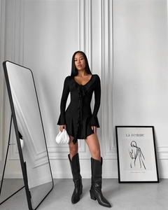 Détail d'une robe noire à manches longues avec volants et décolleté plongeant en V