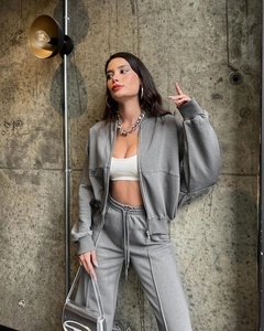 Detailed view of grey zip-up sweatshirt set with matching joggers and chain necklace
