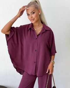 Detail of loose-fit deep purple button-up shirt with wide kimono sleeves and textured fabric