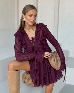 Details von Rüschenschichten und V-Ausschnitt an einem dunkelvioletten Chiffonkleid