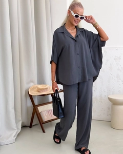 Detailed texture of dark grey crepe fabric on a long-sleeve lapel shirt and trousers set