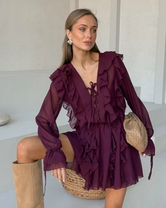Detail eines eleganten burgunderroten Chiffonkleides mit Rüschen-V-Ausschnitt und Trompetenärmel