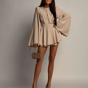 Détail d'une robe mini beige avec manches cloche dramatiques et taille plissée élégante