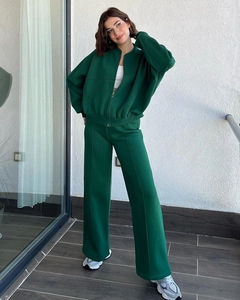 Detail of dark green tracksuit featuring zipper jacket and trousers with vertical seams