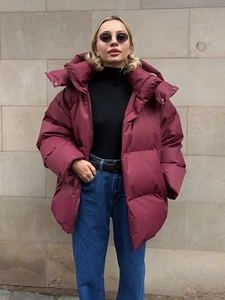 Detail of burgundy oversized puffer jacket with high collar and metallic snap buttons