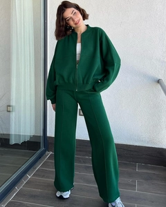 Detailed view of dark green tracksuit featuring zip-up sweatshirt and pleated wide-leg pants