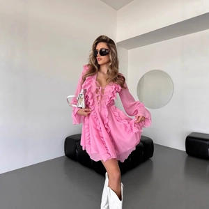 Detail of V-neckline and decorative ruffle trim on pink flowing chiffon dress