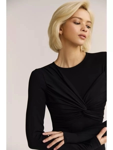 Detail of front twist knot and pleated texture on a long sleeve black bodysuit