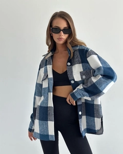 Détail d'une chemise en flanelle à carreaux bleus et blancs avec poches à rabat et boutons