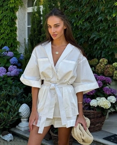 Detailed view of the white cotton set featuring large chest pockets and waist tie detail