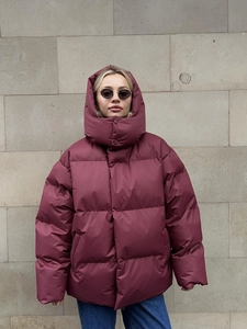 Close-up of wine red oversized hooded puffer jacket with wide horizontal quilting