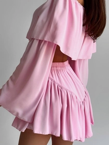 Pink two-piece set featuring off-shoulder ruffle top and high-waisted pleated mini skirt