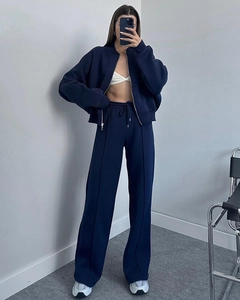 Detail of dark blue zip-up jacket and wide-leg trousers with drawstring waist
