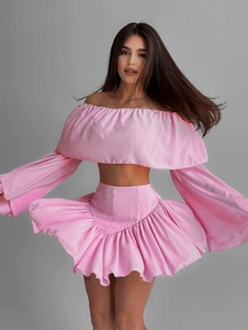 Pink two-piece set featuring off-the-shoulder long sleeve top and ruffled high waist skirt