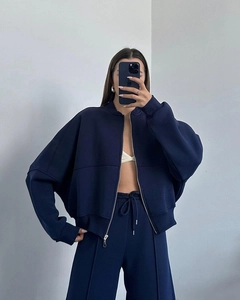 Detail view of the stitching on navy blue zip-up hoodie and matching straight-leg trousers