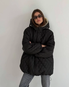 Detail view of black quilted hooded jacket with soft cream sherpa lining for winter