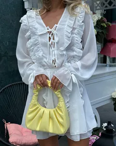 Detailansicht weißes Chiffonkleid mit Schnürung am Ausschnitt und Volants-Besatz