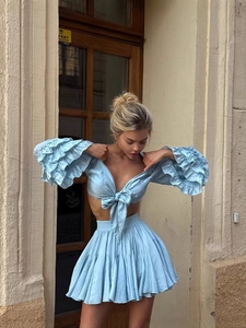 Light blue two-piece set featuring V-neck tie-front top and pleated mini skirt