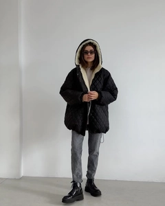 Macro shot of black quilted hooded coat with warm off-white fleece lining for women