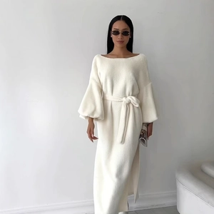 Close-up of white plush maxi dress with elegant off-shoulder neckline and tie-waist detail