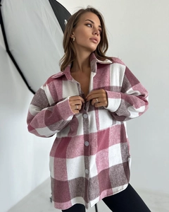 Détail de chemise en flanelle à carreaux rose avec boutons et grandes poches poitrine