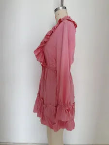 Detail of pink ruffled dress with elastic waist and delicate layered flared sleeves