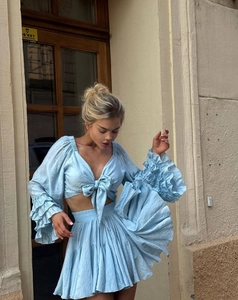 Detailed macro view of the light blue ruffled layered sleeves and bow tie-up on the blouse