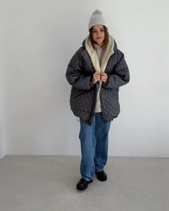 Close-up of quilted hooded parka featuring plush sherpa lining and oversized silhouette