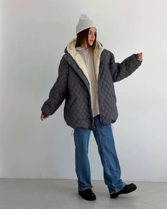Detail of grey quilted jacket featuring thick cream faux shearling lining and a warm hood