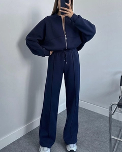 Detail of navy blue tracksuit showing drawstring waist and stitched pleats on wide-leg pants