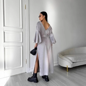 Detail of light gray lantern sleeve dress with elegant open back and side slit