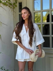 Women's white short sleeve shirt and shorts set with loose fit in a garden setting